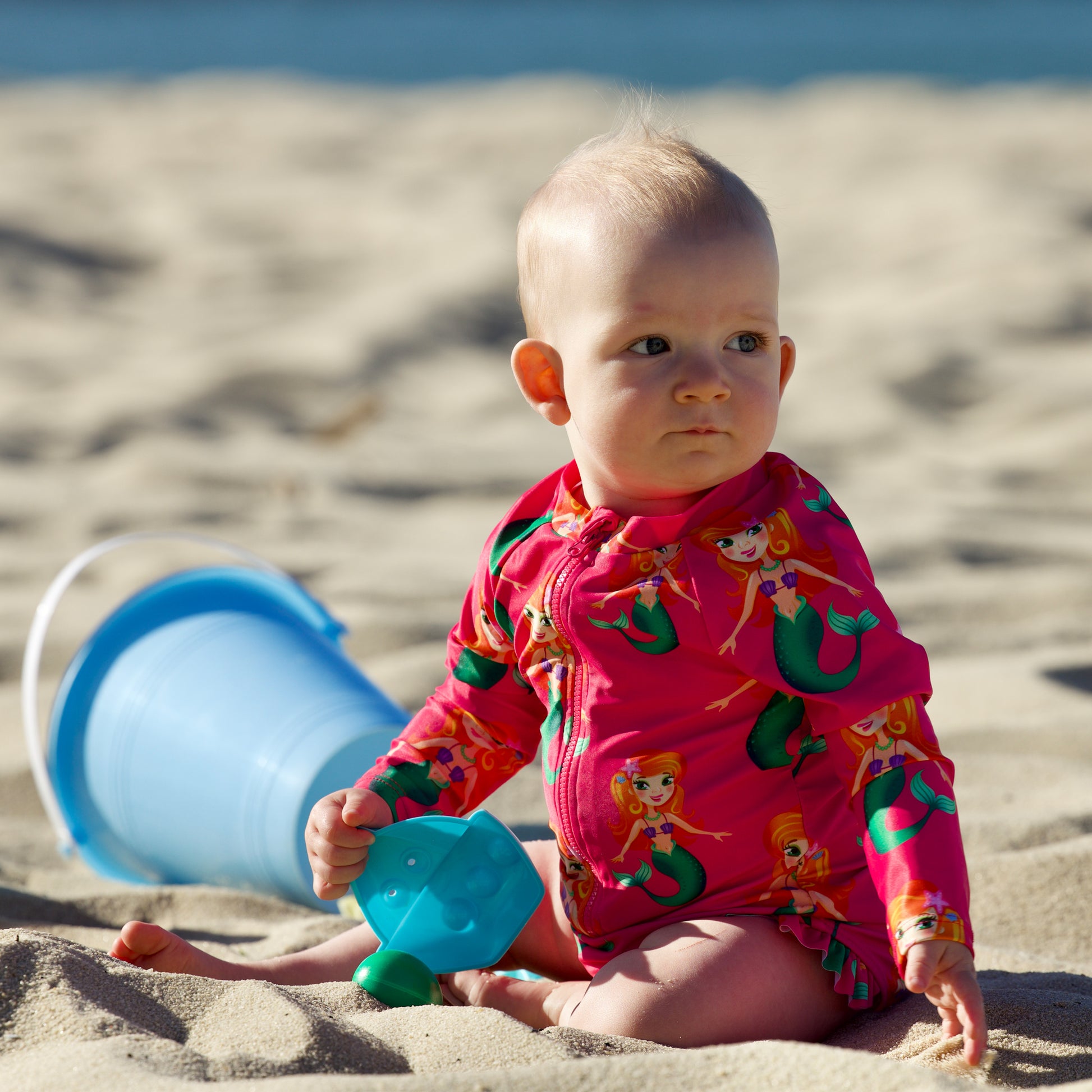 Splashy Tots Pink baby girl swimwear - Girls one piece mermaid pattern swimsuit - Front view at beach